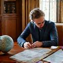 Couple planning bespoke holiday at a luxurious desk with globe and maps