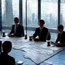Business people in a modern office looking at a world map, planning corporate travel