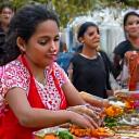 Local woman teaching traditional cooking in a vibrant market setting